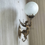 Pair of antique reproduction brass figurine sconces with etched frosted glass globes