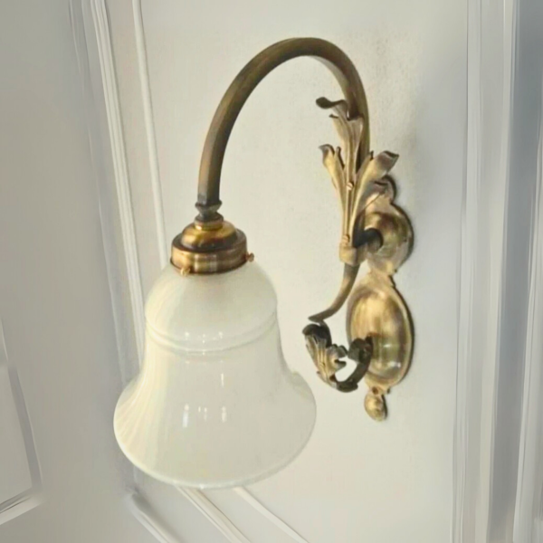 Vintage-style brass floral wall sconce with frosted bell glass